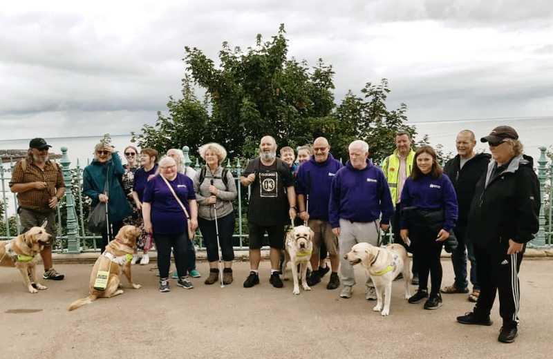 Coastline Sight and Hearing group photo of members and guide dogs on Scarborough's Esplanade
