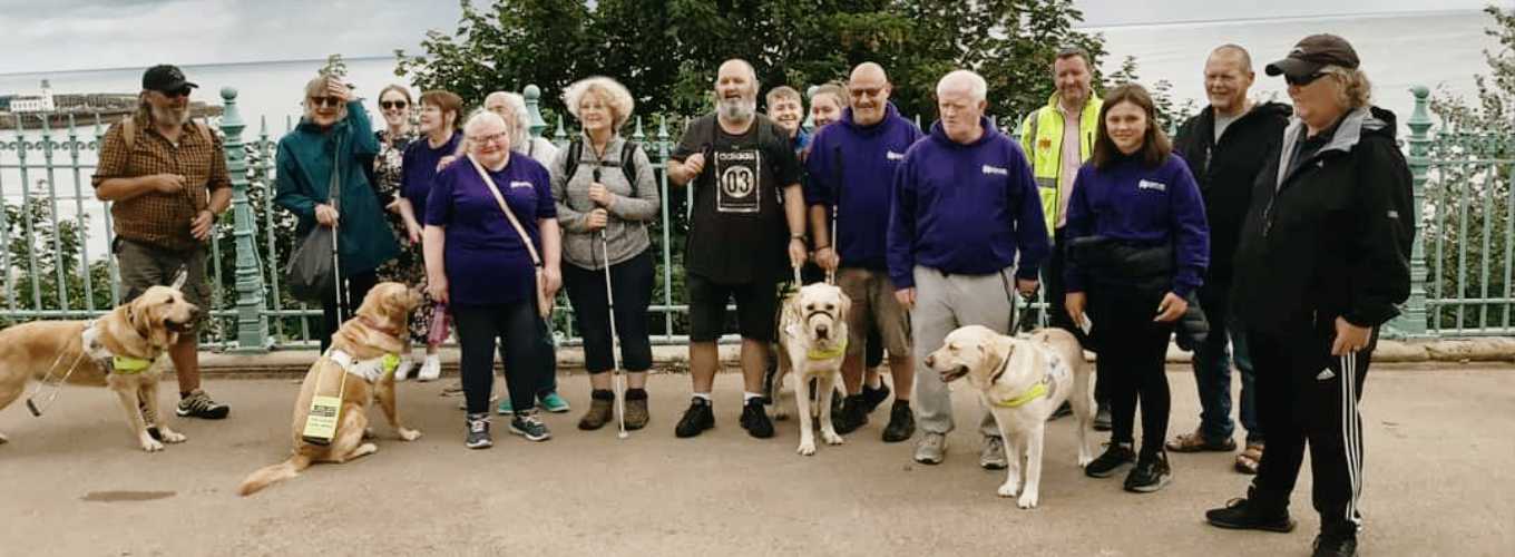 Coastline Sight and Hearing group photo of members and guide dogs on Scarborough's Esplanade