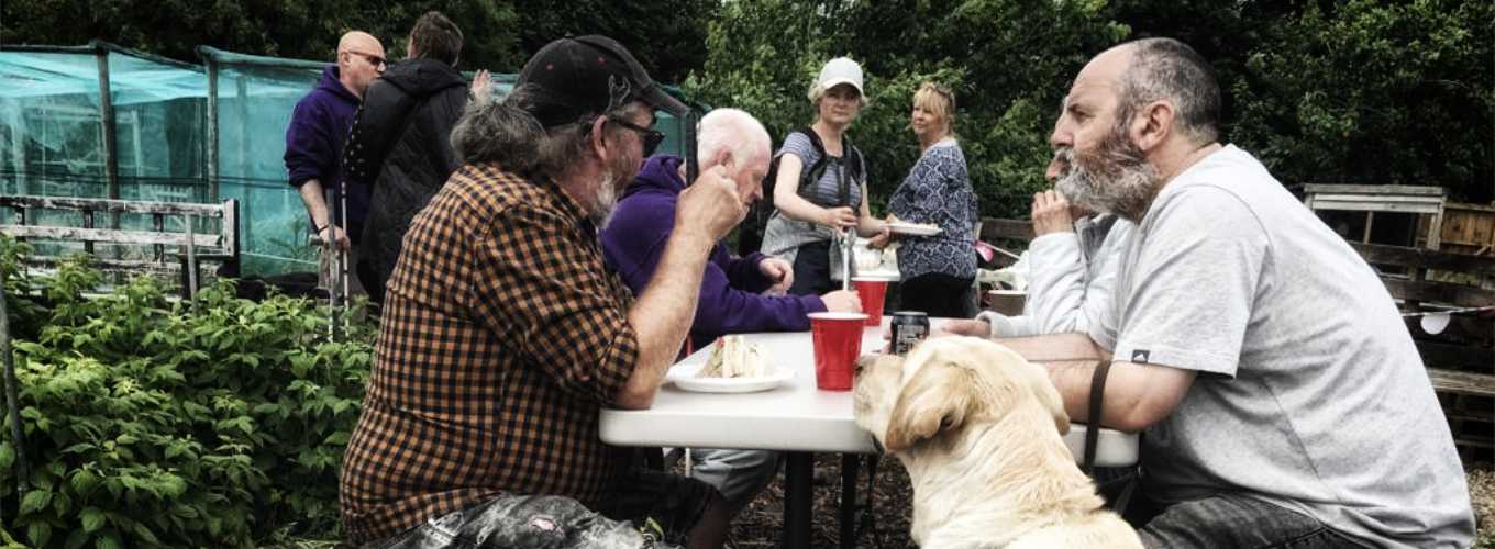 Coastline Sight and Hearing group photo of members and guide dogs attending a picnic at Scalby garden allotments